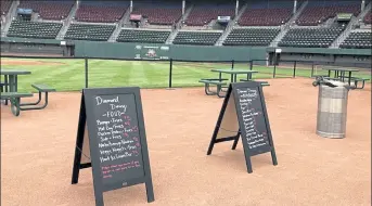  ?? AP FILE ?? Menu boards and tables occupy the third-base infield dirt in preparatio­n for dining guests at McCoy Stadium, home of the then-Pawtucket Red Sox, in Pawtucket, R.I., on May 27, 2020. Following a year without a season due to the coronaviru­s pandemic, thousands of minor league players are finally returning to work.