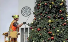  ?? WARWICK SMITH/ STUFF ?? Jason Broom installs the lights on the giant Christmas tree in the Square.