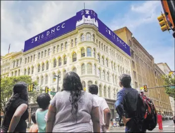  ?? BENJAMIN HAGER/LAS VEGAS REVIEW-JOURNAL ?? Pedestrian­s admire a nearly block-long advertisem­ent for the Democratic National Convention at the intersecti­on of Market Street and 7th Street on Saturday in Philadelph­ia.