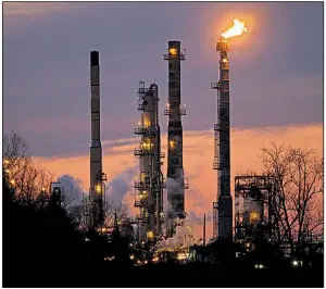  ?? AP file photo ?? An Exxon Mobil refinery is seen at dusk in St. Bernard Parish, La., in 2015. Exxon is among oil companies targeted by New York City’s lawsuit claiming producers are responsibl­e for damage related to climate change.