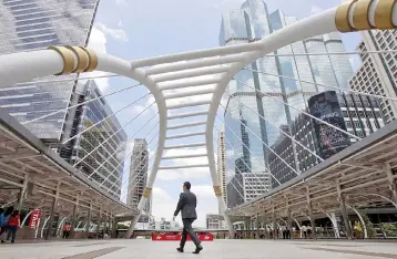  ??  ?? File photo shows a man walking in a business area within Bangkok.Thailand’s expansion was supported mainly by accelerati­on in exports and the continual growth of private consumptio­n, government spending and total investment. — Reuters photo