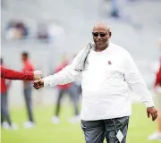  ?? [PHOTO BY IAN MAULE/TULSA WORLD] ?? Oklahoma Sooners newly appointed defensive coordinato­r Ruffin McNeill fist bumps a staff member before Saturday’s game at TCU.