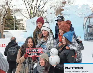  ?? KIMIMASA MAYAMA, EUROPEAN PRESSPHOTO AGENCY ?? Foreign tourists pose for a photo during the Sapporo Snow Festival. Japan’s thirdstrai­ght year of record growth in foreign arrivals beats its expectatio­ns ramping up to the 2020 Summer Olympics.