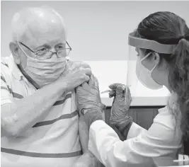  ?? SUSAN STOCKER/SOUTH FLORIDA SUN SENTINEL ?? Nelson Dayton, 91, a John Knox Village resident, receives his first dose of the Pfizer COVID-19 vaccine from Walgreens pharmacist Rachel Brodskiy on Jan. 19 in Pompano Beach.