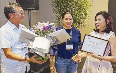  ??  ?? Richie Yang and Jeanette Tuason present a plaque of appreciati­on to Dr. Vicki Belo.