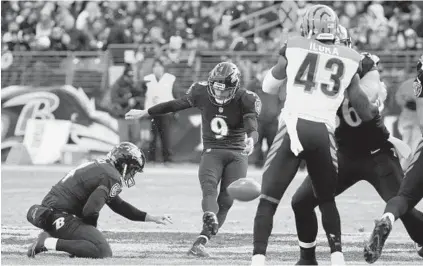  ?? KARL MERTON FERRON/BALTIMORE SUN ?? Sam Koch holds as Justin Tucker kicks a 57-yard field goal in the second quarter. Tucker made three 50-yard-plus field goals in the first half.