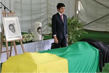  ?? TIMOTHY BERNARD African News agency (ANA) ?? A SPECIAL provincial official funeral was held for Ebrahim Ismail Ebrahim. Here his son Kadin Ebrahim stands at the coffin of the late Struggle stalwart. |