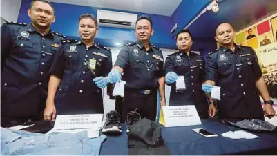  ?? [FOTO MALAI ROSMAH TUAH /BH] ?? Habibi (tengah) menunjukka­n barangan yang dirampas dalam kes samun dan dadah pada sidang media IPD Kota Kinabalu. semalam.