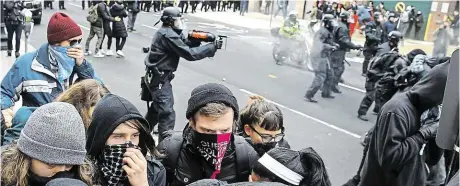  ?? Při protestech v centru Washington­u policie zadržela na devět desítek demonstran­tů, kteří rozbili několik výloh obchodů. FOTO REUTERS ?? Střety v ulicích.