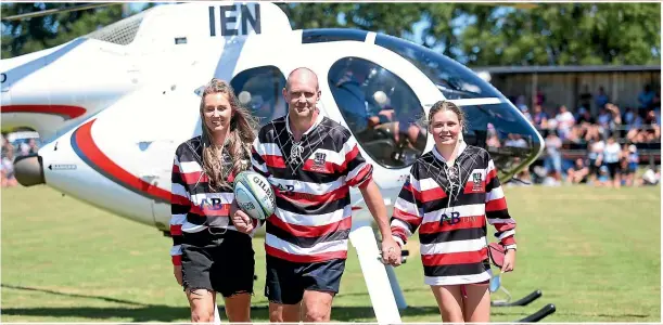  ??  ?? Blair Vining delivers the ball with daughters Della-May, 16, and Lilly, 12, to yesterday’s starstudde­d rugby match.