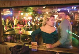  ?? STEPHEN M. KATZ/STAFF ?? Anna Nutter, with Daniel Flack looking over the dance floor, glances back to the person singing karaoke in the smoking section.