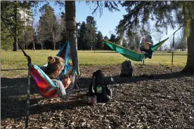  ?? PHOTOS BY BRITTANY PETERSON — THE ASSOCIATED PRESS ?? Megan Vanderhoof­t, left, and Sarah Fee, right, lounge in hammocks at Cheesman Park on Wednesday, in Denver.