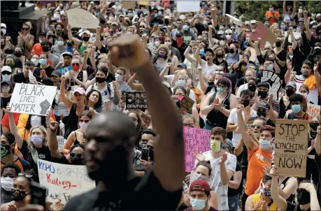  ?? CHARLIE RIEDEL —ASSOCIATED PRESS ?? People hold signs as they listen to a speaker in front of city hall in downtown Kansas City, Mo., June 5 during a rally to protest the death of George Floyd who died after being restrained by Minneapoli­s police officers on May 25.