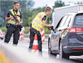  ?? FOTO: DPA ?? Polizisten überprüfen an der Kontrollst­elle Kiefersfel­den an der Autobahn 93 Fahrzeuge, die aus Österreich nach Deutschlan­d kommen.