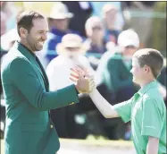  ?? Jamie Squire / Getty Images ?? Nicholas Gross, right, shakes hands with Sergio Garcia during the Drive, Chip and Putt Championsh­ip at Augusta National Golf Club on Sunday.