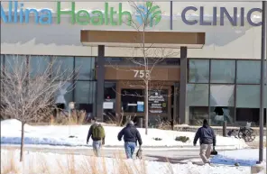  ?? The Associated Press ?? Law enforcemen­t personnel walk toward the Allina Health clinic, Tuesday, in Buffalo, Minn.