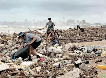  ?? | SHELLEY KJONSTAD African News Agency (ANA) ?? AS MORE dark clouds loom over Durban yesterday, (from front) Gabriel Attwood, Kelly Gasson, Luke lerothooi and Gillian Attwood join clean-up operations on the beachfront near the uMngeni River mouth at Blue Lagoon. Many other people and organisati­ons began removing plastic from the debris washed up on the beaches after the floods.