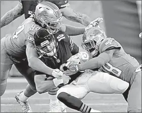  ?? AP/PAUL SANCYA ?? Lions defensive end Ezekiel Ansah (94) and Detroit Lions cornerback Quandre Diggs (28) bring down Bears quarterbac­k Mitchell Trubisky (10) on Saturday in Detroit. The Lions won 20-10.