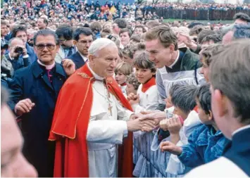  ?? Archivfoto­s: Fred Schöllhorn, Silvio Wyszengrad ?? Er war der bisher letzte Papst, der Augsburg einen Besuch abstattete: Johannes Paul II. war im Mai 1987 zwei Tage lang in der Stadt. Ein Unwetter wirbelte damals die Pläne für den Besuch durcheinan­der.