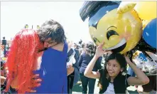  ??  ?? ABOVE: Cruz Hermoso hugs her son, Erick Anthony Sanchez, as his little sister, Diamonique Sanchez, holds balloons for him after Santa Fe High School’s commenceme­nt ceremony Thursday.
RIGHT: Principal Carl Marano checks out Diego Herrera Salinas’...