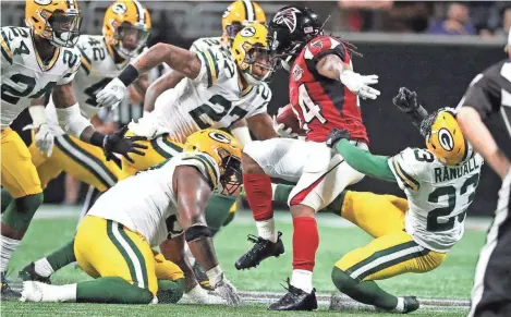  ?? RICK WOOD / MILWAUKEE JOURNAL SENTINEL ?? A host of Packers defenders close in on Falcons running back Devonta Freeman. The defense had trouble containing Freeman and the other playmakers in Atlanta’s offense on Sunday night.