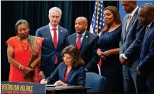  ?? MARY ALTAFFER — THE ASSOCIATED PRESS ?? New York Gov. Kathy Hochul, center, signs a package of bills to strengthen gun laws on June 6 in New York.