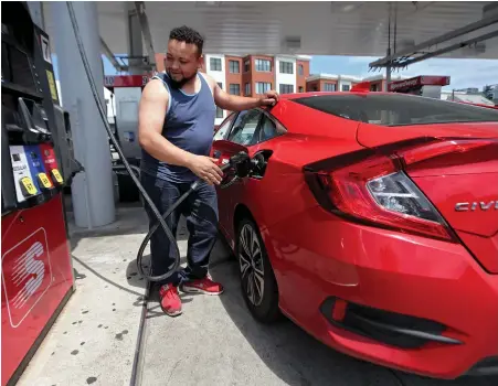  ?? STAFF PHOTO BY NANCY LANE ?? FILL ’ER UP, UP, UP: Pedro Lopes pumps gas in Dorchester yesterday. Experts say gas prices, already 66 cents higher than this time last year in the Bay State, could climb again later this summer, when prices usually come down.