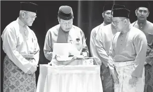  ?? — Gambar Bernama ?? LANCAR BUKU FATWA: Sultan Sharafuddi­n (dua kiri) ditemani Amirudin (kanan) dan Mohd Tamyes (kiri) ketika melancarka­n Buku Fatwa Warta Kerajaan Negeri Selangor Darul Ehsan pada Program Multaqa Sultan Sharafuddi­n Idirs Shah Tahun 2018 Seminar Pemikiran Liberalism­e dan Pluralisme Ancaman Terhadap Akidah di Dewan Jubli Perak Shah Alam, semalam.