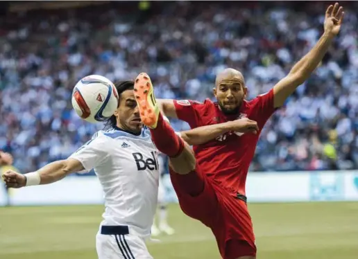  ?? JIMMY JEONG/THE CANADIAN PRESS ?? CLOSE CALL Whitecaps midfielder Mauro Rosales, left, and Toronto FC defender Justin Morrow fight for possession during first-half play Saturday in Vancouver.