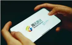  ??  ?? A Tencent Games logo from an app is seen on a mobile phone in this illustrati­on picture. Tencent will expand an addiction-prevention system for underage gamers to all of its games, the company said yesterday, as the industry faces increased government scrutiny.