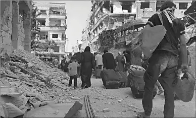  ?? Associated Press ?? Syrian citizens carry their belongings as they prepare to evacuate Friday from Daraya, a blockaded Damascus suburb.