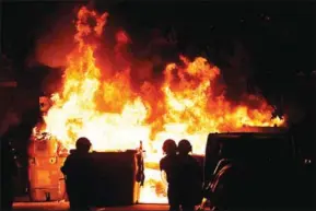  ?? LLUIS GENE/AFP ?? Anti-riot police officers stand close to a burning barricade during a demonstrat­ion called by the Committees for the Defence of the Republic in Barcelona on Wednesday.