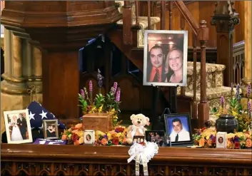  ??  ?? A unity urn with cremated ashes of Robert Joseph Dyson and Mary E. Dyson is set in place as friends and family prepare for a funeral mass at St. Stanislaus Roman Catholic Church in Amsterdam, N.Y. AP PhOtO/hAnS PennInk