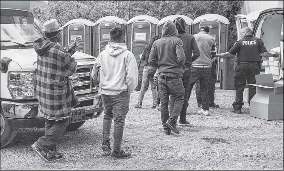  ?? CP PHoTo ?? Asylum seekers line up to receive boxed lunches after entering Canada from the United States at Roxham Road in Hemmingfor­d, Que., earlier this month.