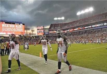  ?? JASON BEHNKEN/ASSOCIATED PRESS ?? Tampa Bay Buccaneers players leave the field as storm clouds, that delayed the game by more than an hour, move over the stadium.