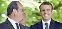  ??  ?? French President Francois Hollande (L) looks as newly elected President Emmanuel Macron smiles during a ceremony to mark the anniversar­y of the abolition of slavery and to pay tribute to the victims of the slave trade on May 10, 2017 at the Jardins du...