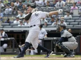  ?? BILL KOSTROUN — THE ASSOCIATED PRESS ?? New York Yankees’ Aaron Judge hits a two-run home run as Seattle Mariners catcher Mike Zunino, right, looks on during the first inning of a baseball game Thursday at Yankee Stadium in New York.