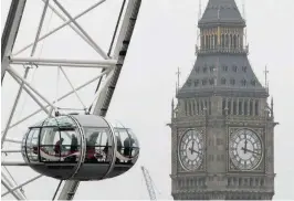  ?? — Reuters ?? People ride in a capsule of the London Eye in front of the Big Ben clock tower in London on Thursday.