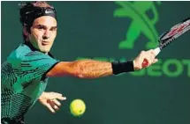  ?? AL BELLO/GETTY IMAGES ?? Roger Federer returns a shot during his 6-2, 3-6, 7-6 (6) quarterfin­al victory over Tomas Berdych at the Miami Open on Thursday.