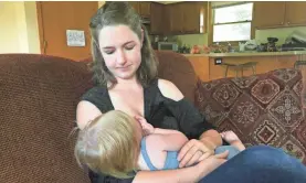  ?? SUSAN BROMLEY/LIVINGSTON DAILY ?? Amy Marchant of Brighton, Michigan, nurses her 1-year-old daughter Autumn at home.