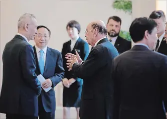  ?? ANDY WONG THE ASSOCIATED PRESS ?? America’s Wilbur Ross, centre, speaks with Chinese Vice-Premier Liu He, left, after a Beijing meeting Sunday.