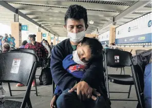  ?? PHOTO: REUTERS ?? Weary . . . A migrant who crossed Gateway Internatio­nal Bridge from the Mexico side to be processed to seek asylum in the US waits with a child at a bus terminal in Brownsvill­e, Texas.