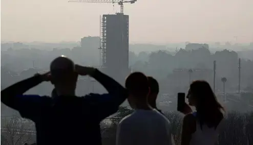  ?? ?? Des athlètes font une pause alors qu'ils courent sur la colline de San Siro et regardent l'horizon de Milan, Italie, mardi 20 février 2024.