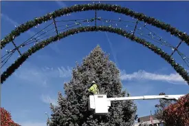  ?? BILL LACKEY / STAFF ?? Members of the City of Springfiel­d Service Department wrap the city’s holiday tree in thousands of light on the Springfiel­d Esplanade earlier this month in preparatio­n for Holiday in the City.