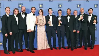  ??  ?? The cast and crew of ‘La La Land’ poses in the press room with the award for best motion picture - musical or comedy.