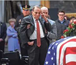  ?? JACK GRUBER/USA TODAY ?? Former Sen. Bob Dole salutes the casket of President George H.W. Bush lying in state Tuesday at the U.S. Capitol Rotunda.