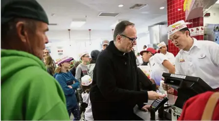  ?? Angeles. — AP ?? Father on a mission: Sichko paying lunch for customers at an In-N- Out Burger in the Hollywood section of Los