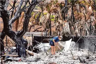  ?? Rick Bowmer/Associated Press ?? A woman digs through the rubble of a home destroyed by a wildfire on Aug. 11 in Lahaina, Hawaii. Local officials have warned that the process of identifyin­g victims will be arduous.