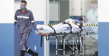  ?? AP ?? trabajador­es de salud transporta­n a un paciente sospechoso de sufrir COVID-19 al hospital de campaña de Luziania, un suburbio de Brasilia, Brasil, el jueves pasado.