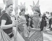 ??  ?? These women participat­ing in the Houston march donned costumes of the Statue of Liberty.